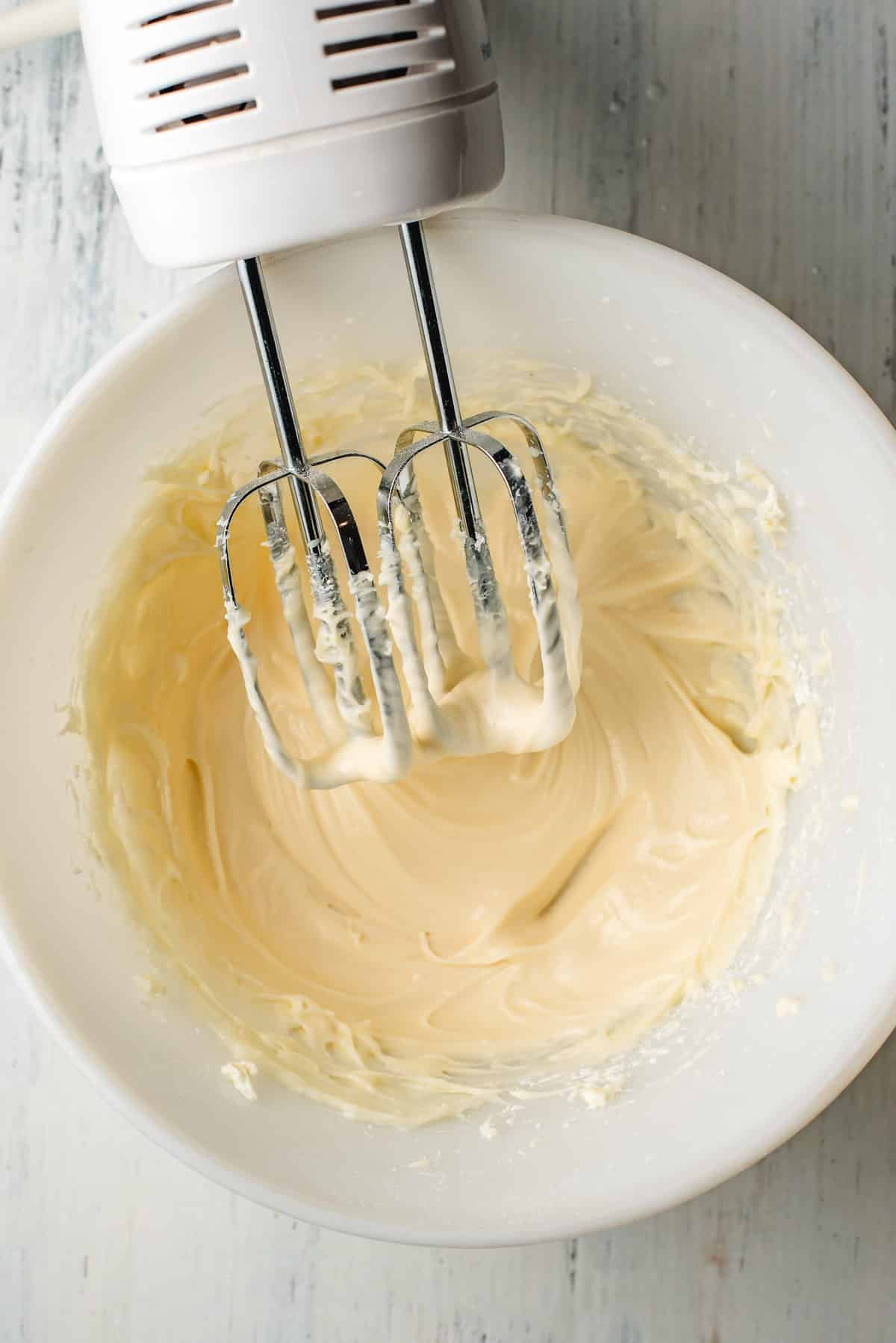Cream cheese frosting in a white bowl.