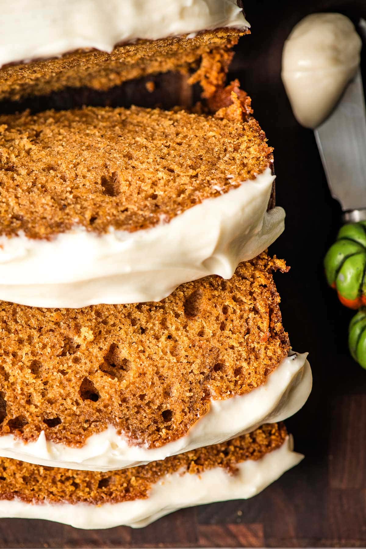 Three slices of frosted pumpkin bread.