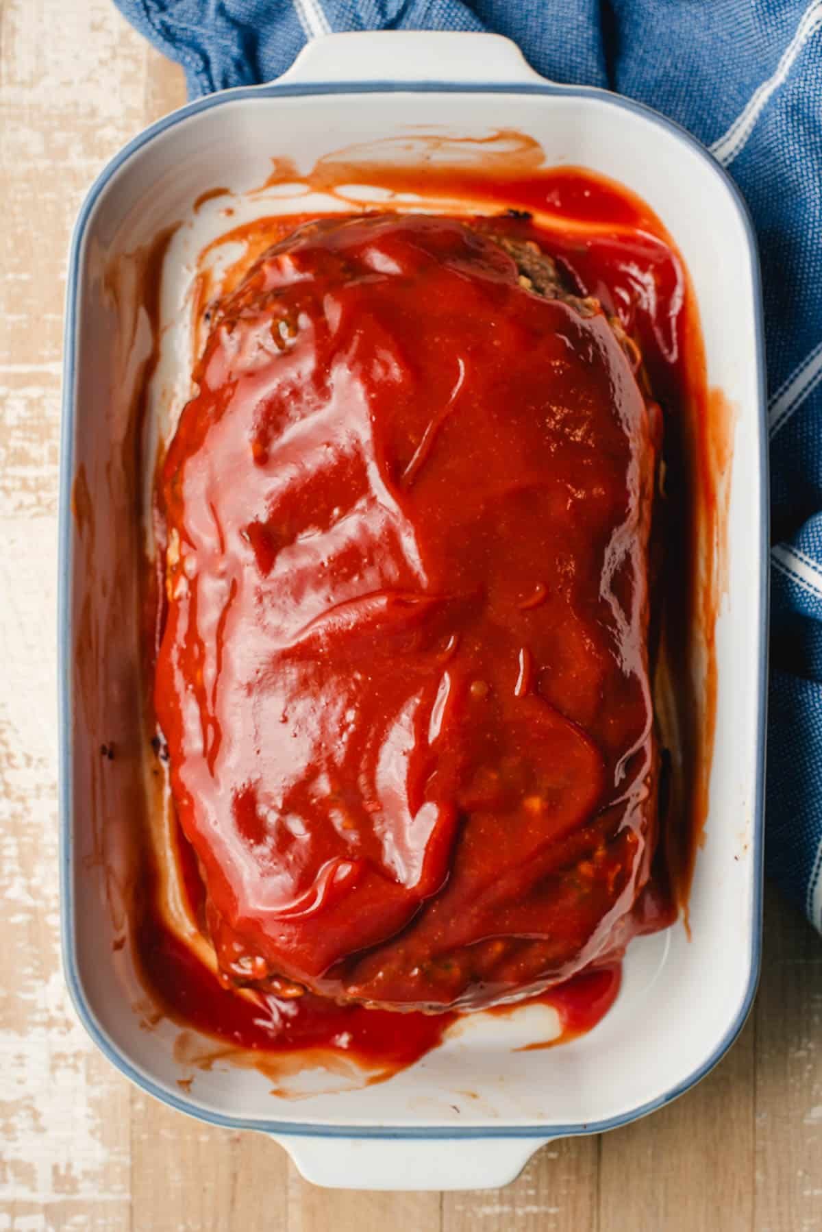 Meatloaf topped with ketchup glaze in a casserole dish.
