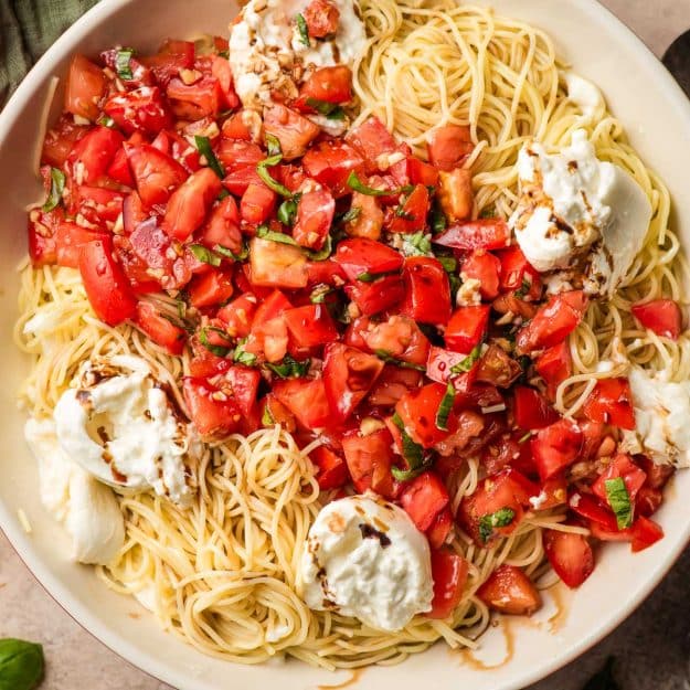 Bruschetta pasta with burrata cheese and angel hair in a bowl.