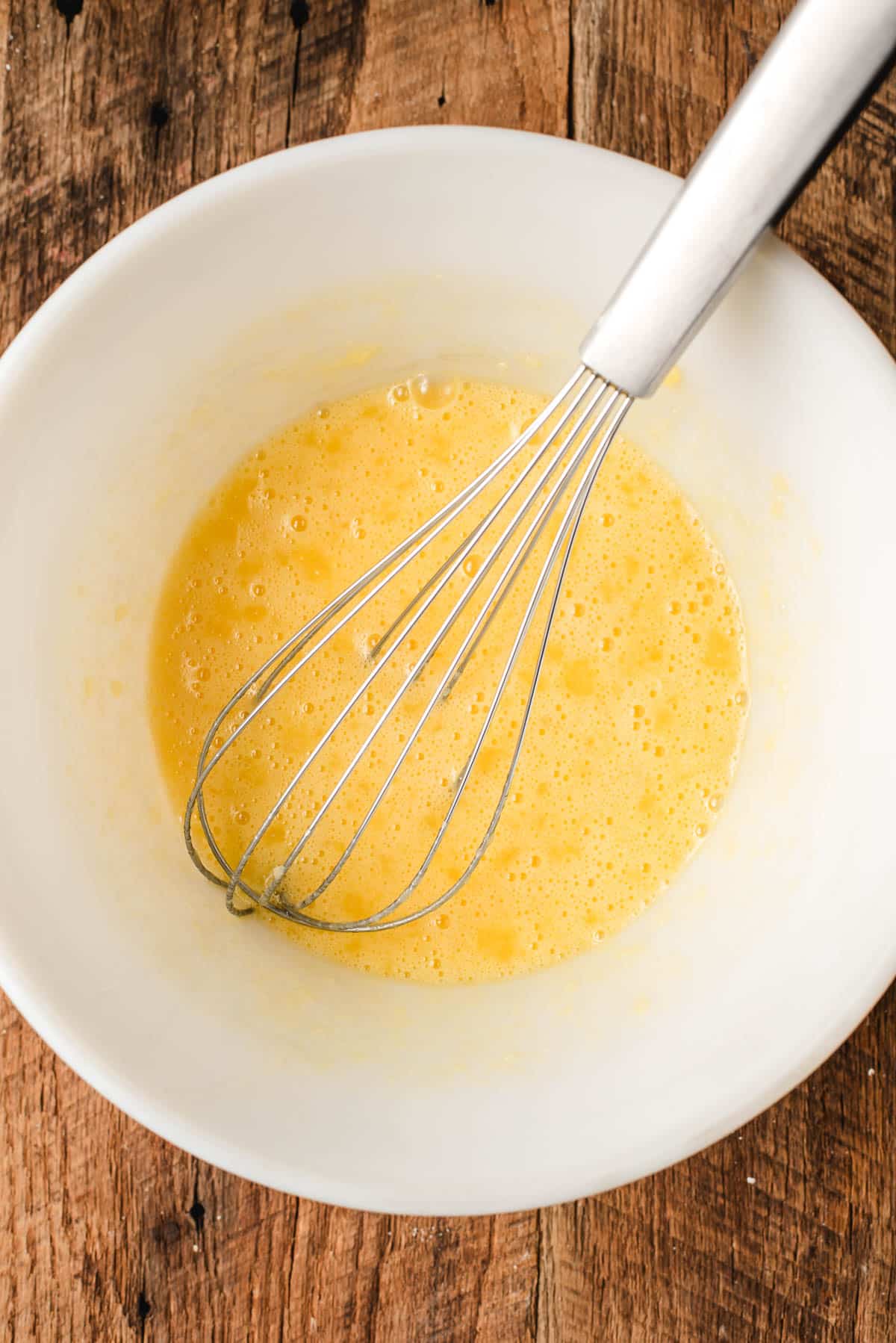 whisking eggs in a large mixing bowl