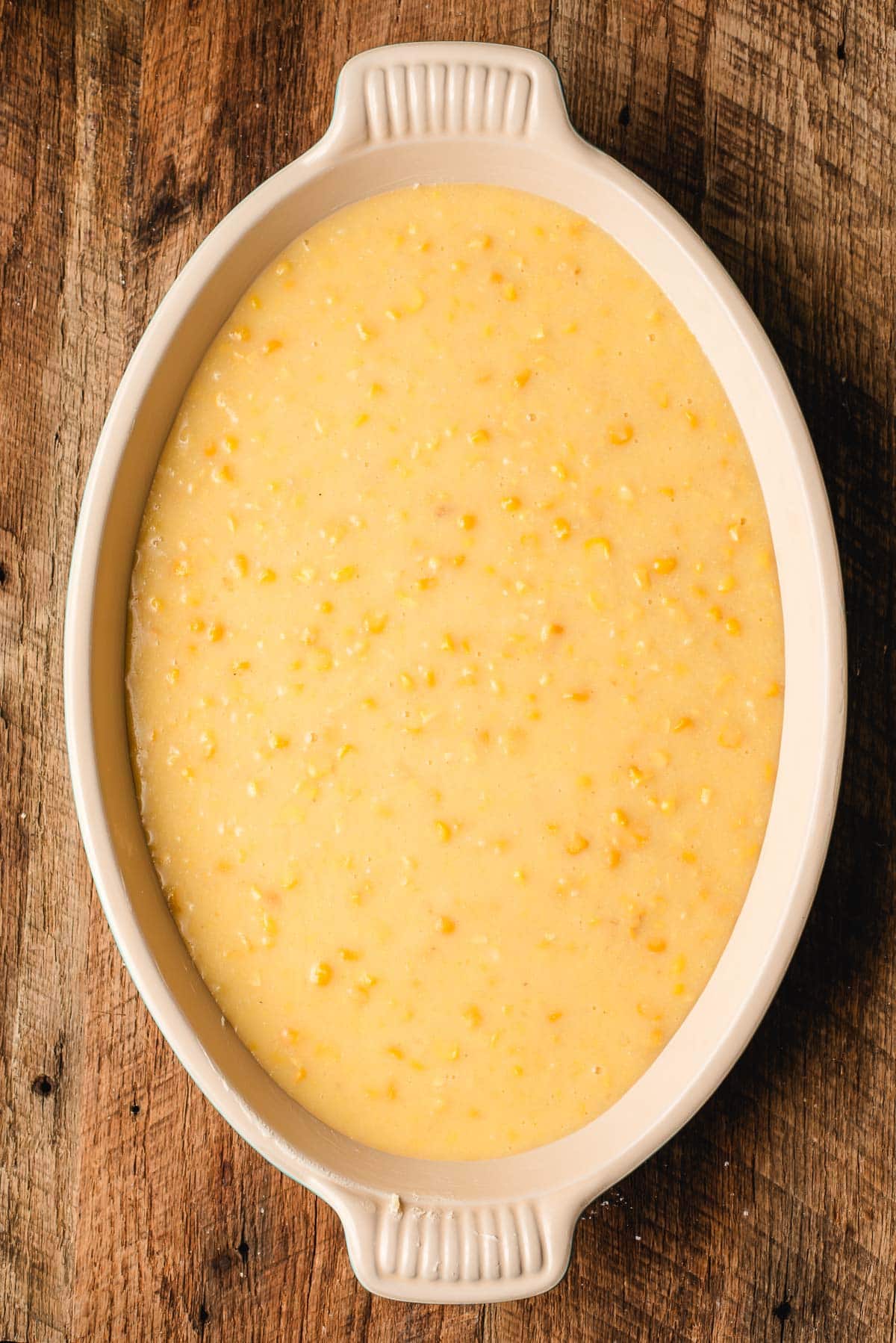 corn souffle in an oval pan, ready to be baked.