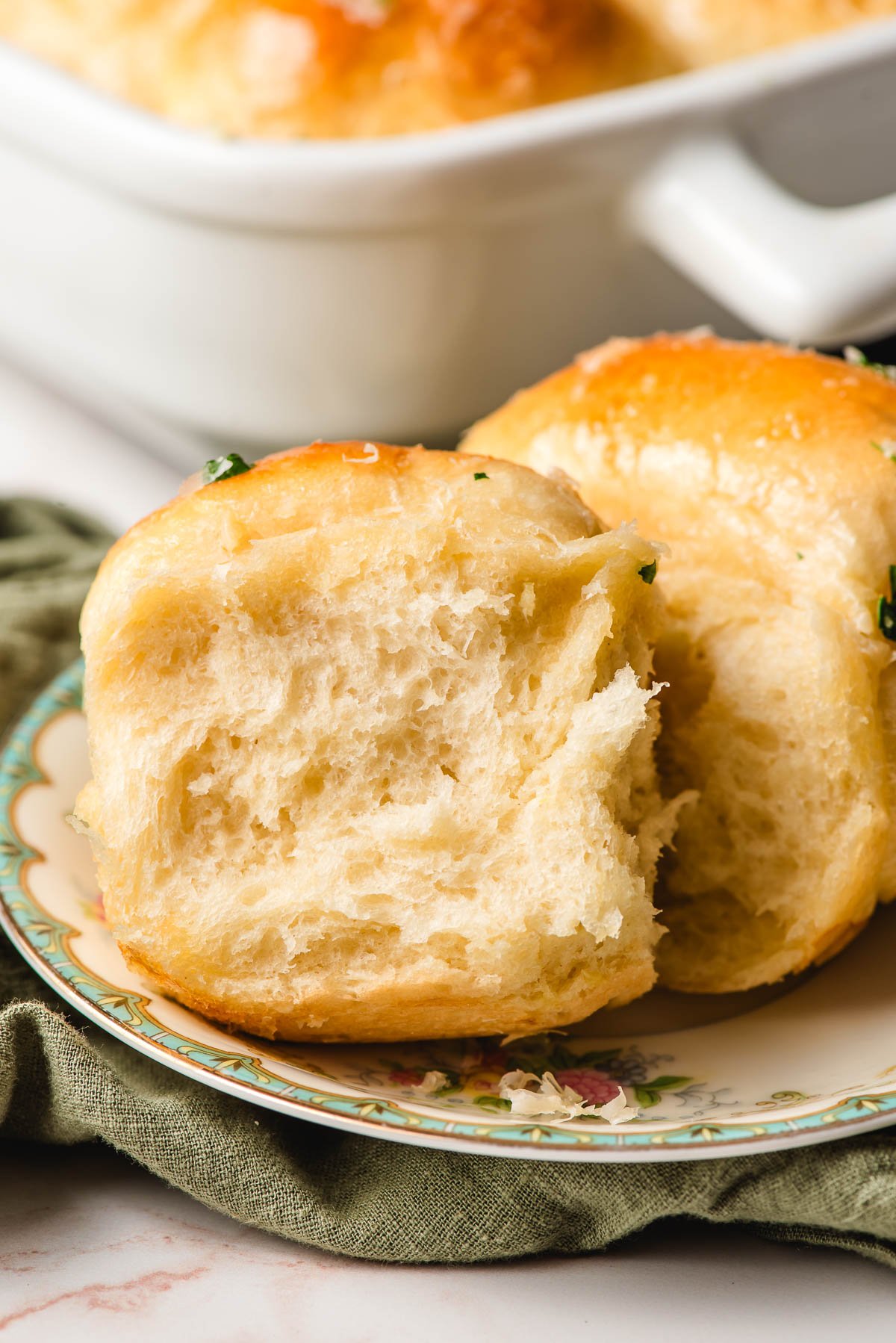 Two garlic dinner rolls on a pretty plate.