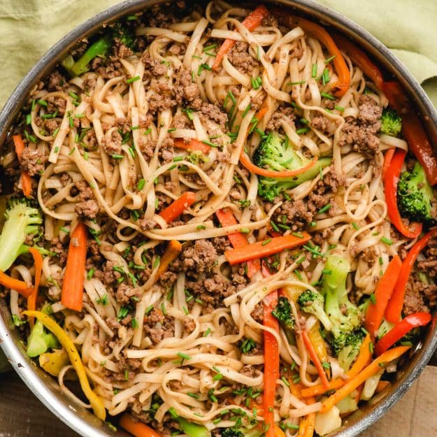 Ground beef lo mein with veggies in a large deep skillet.