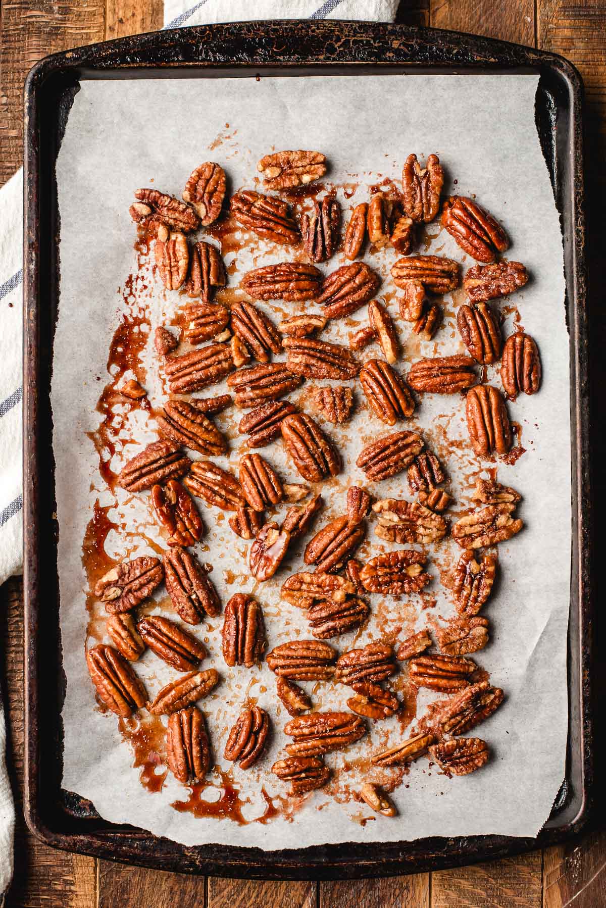 Pecans on a sheet pan, roasted with maple syrup.