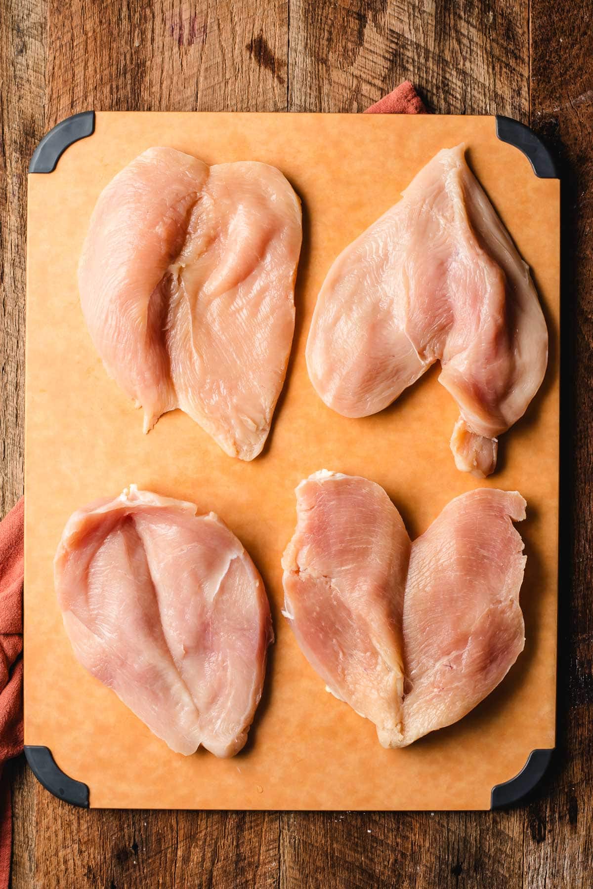 butterflying chicken breasts on a cutting board 