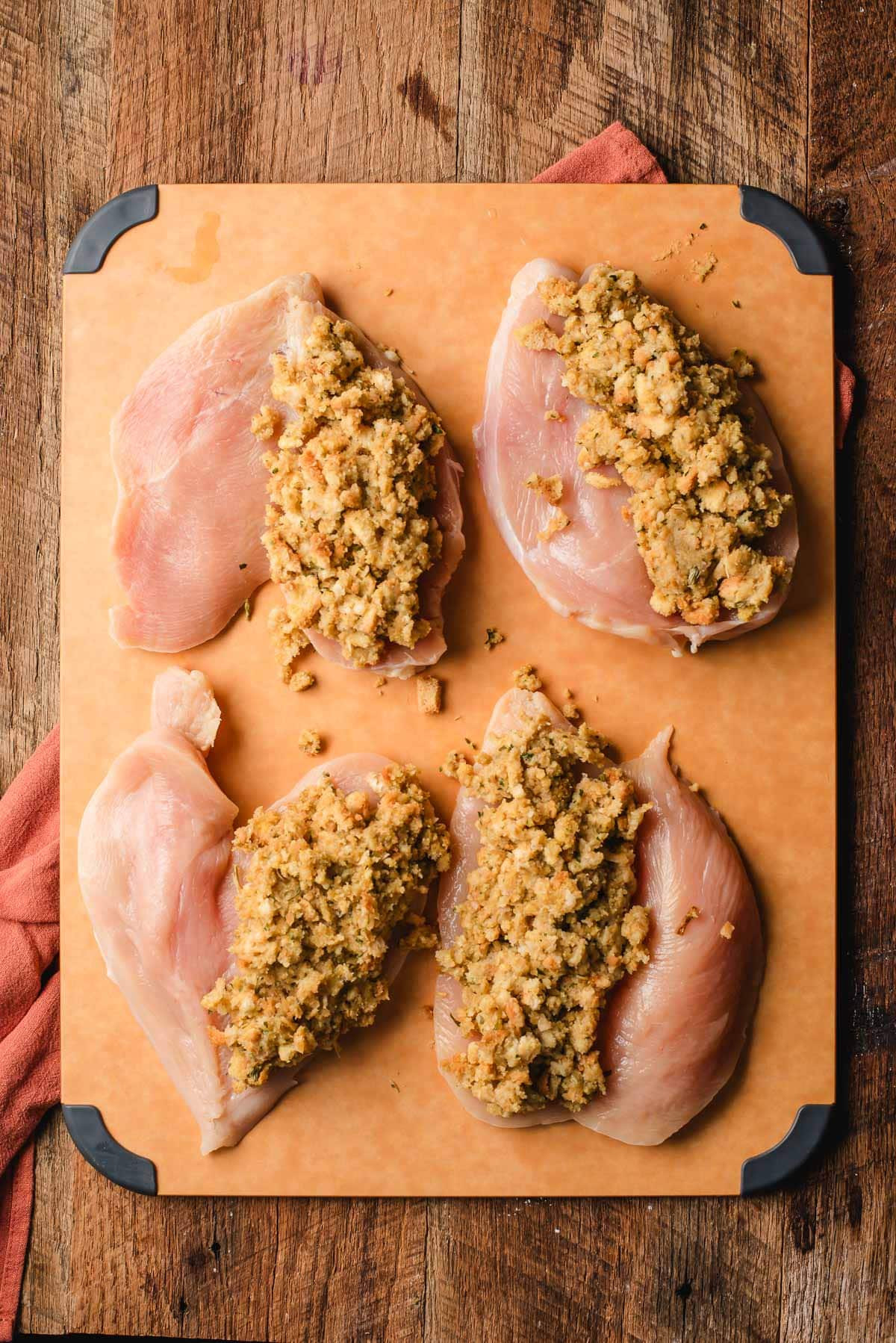 stuffing resting on the butterflied chicken breast to make stuffing stuffed chicken