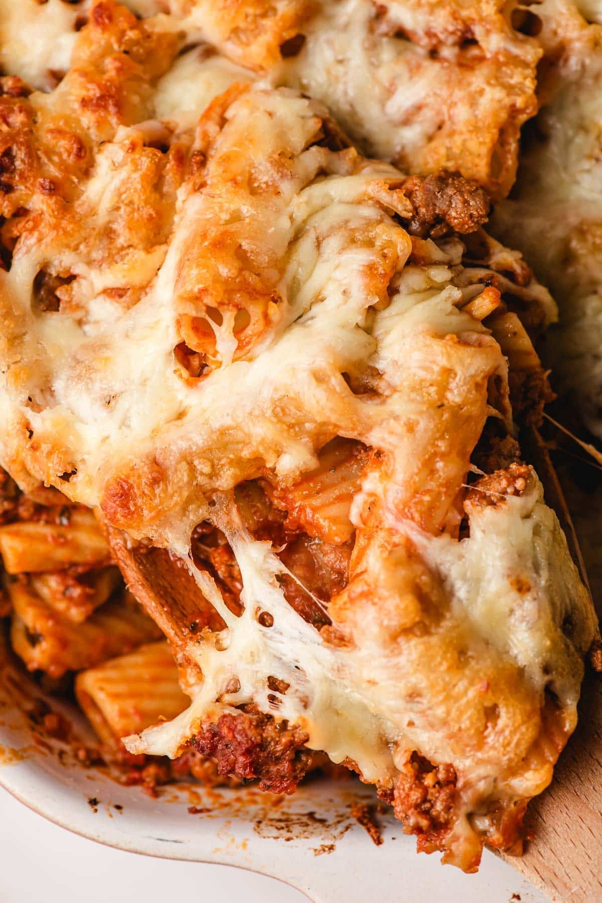 Gooey cheese strings on baked rigatoni.