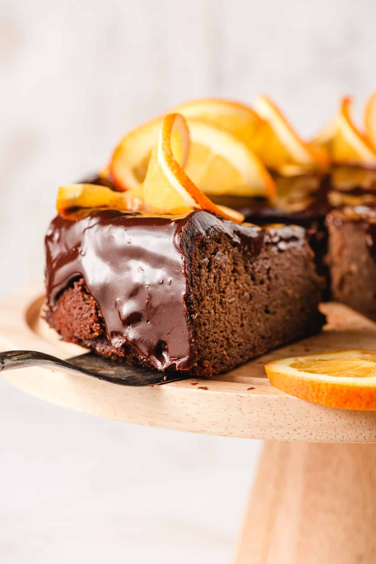 a slice of flourless chocolate orange cake on top of a cake stand.