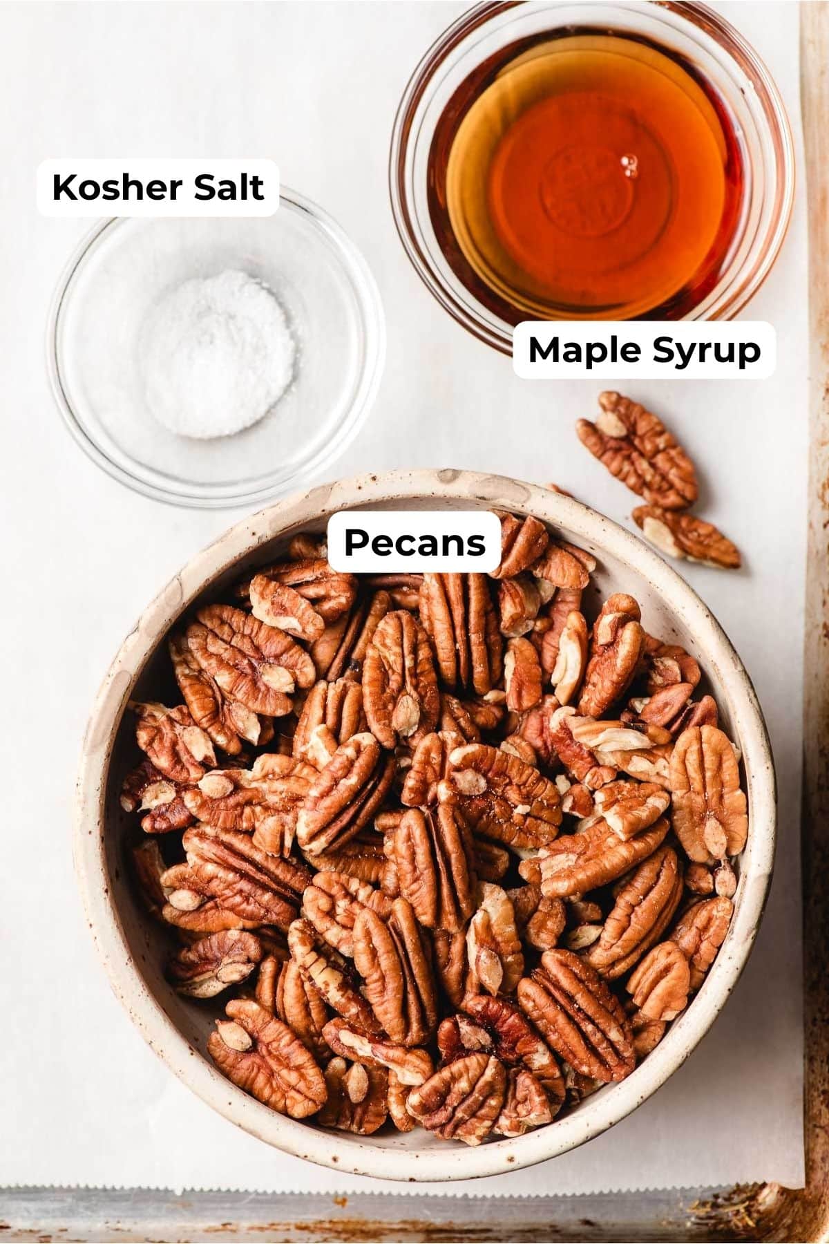 Bowls of pecan halves, maple syrup, and salt.