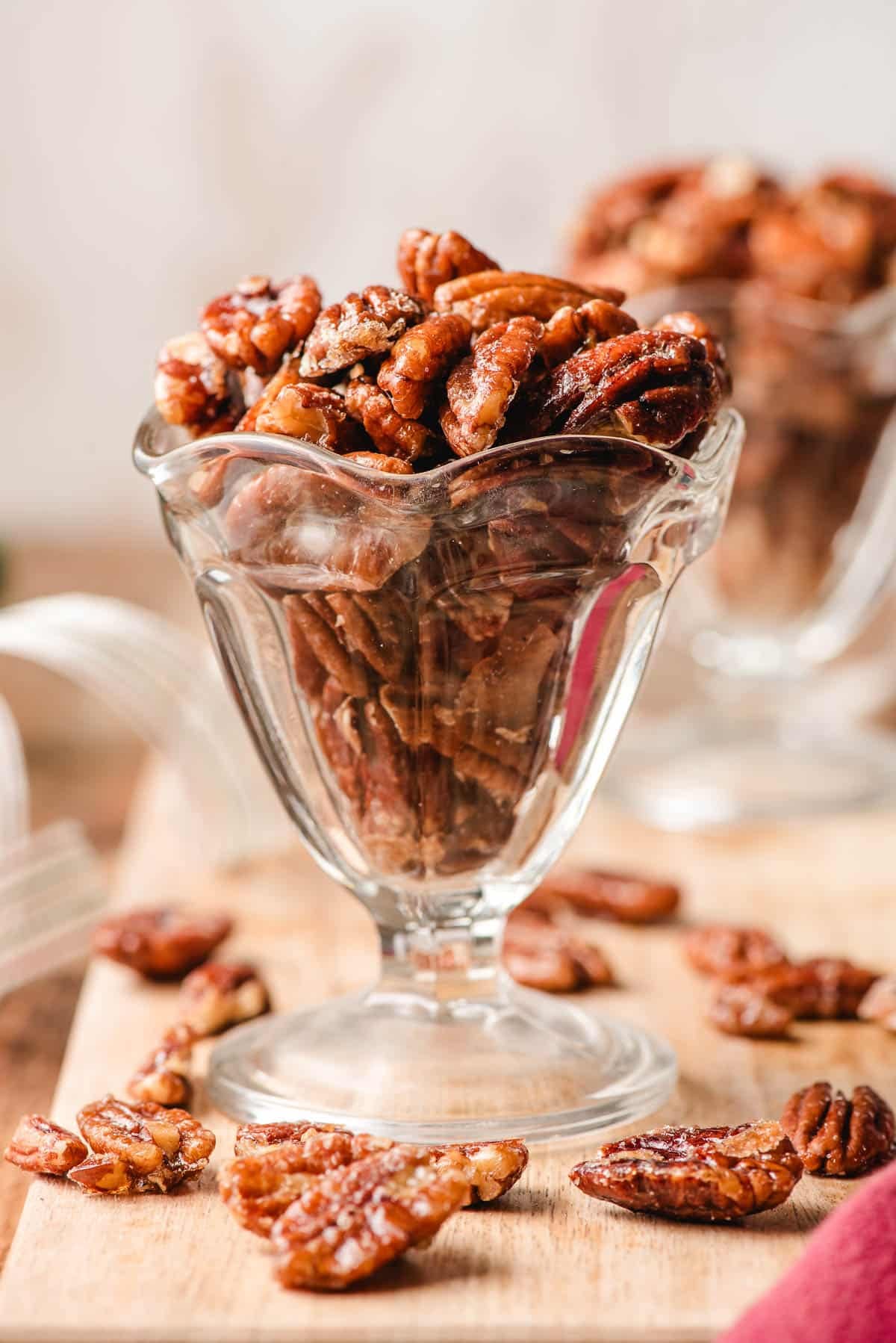Glass ice cream dish filled with roasted maple pecans.