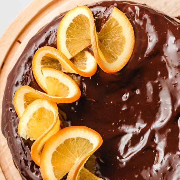 fudgy and flourless chocolate orange cake topped with chocolate ganache and orange slices