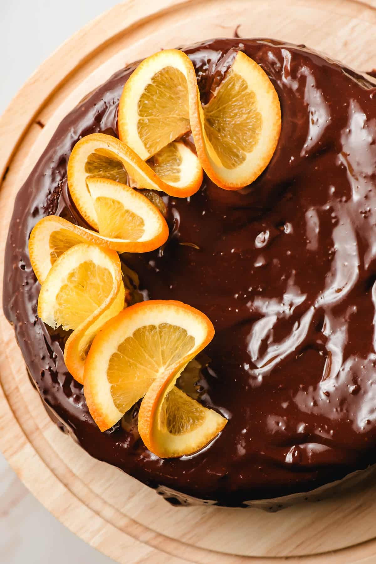 a finished chocolate orange cake covered in chocolate ganache topped with spiraled orange slices
