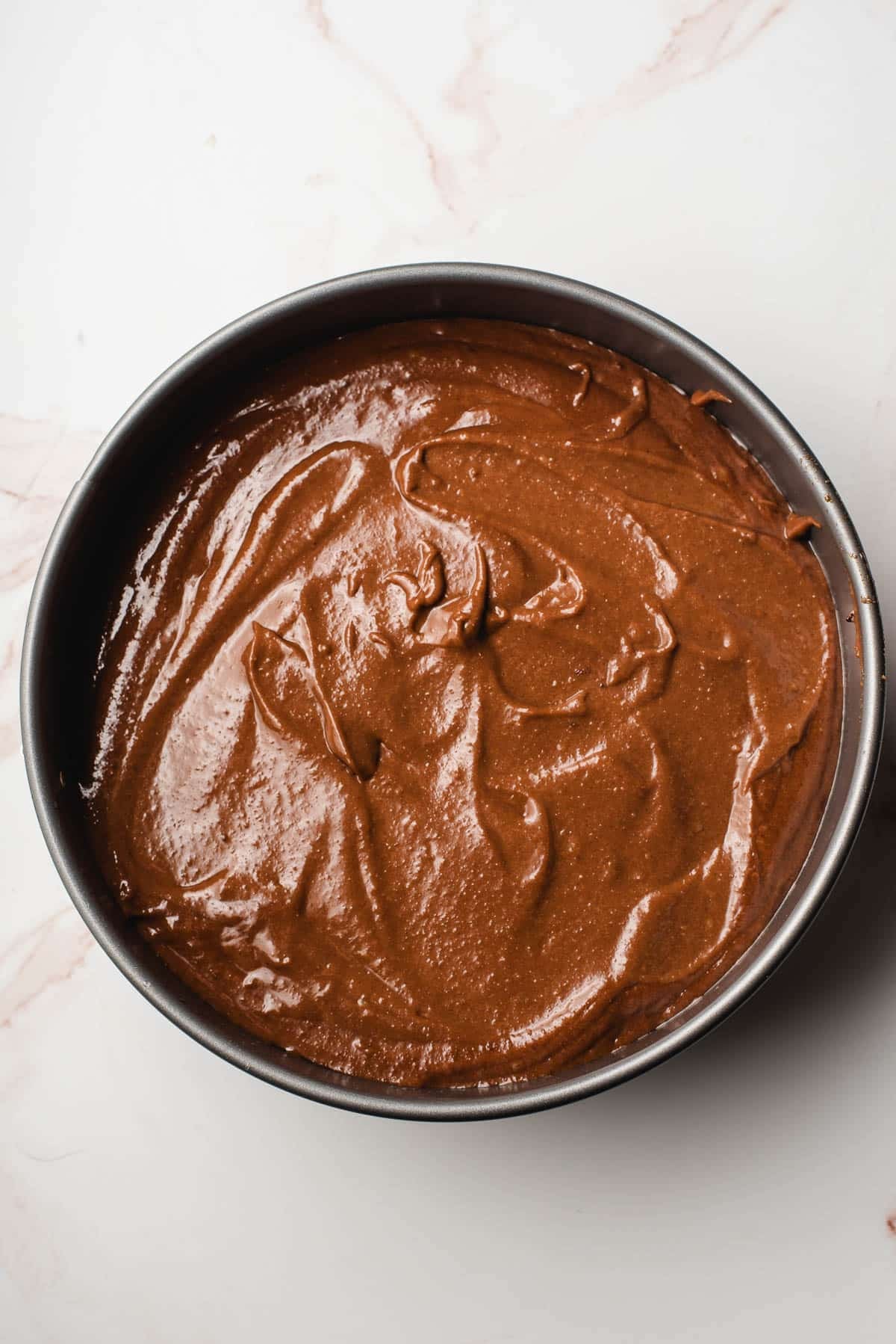 chocolate orange cake batter in a springform pan ready to be baked
