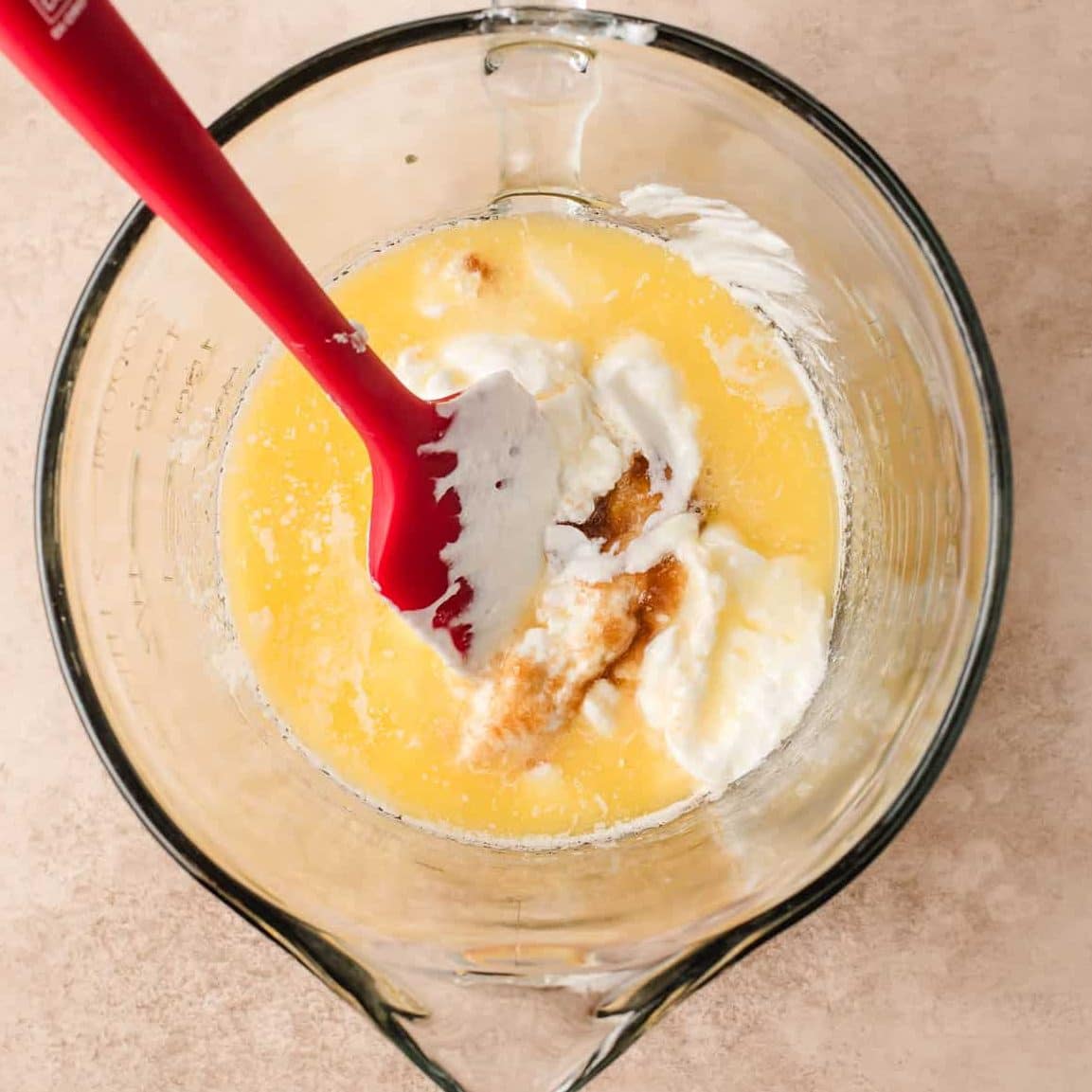 Melted butter, yogurt, sour cream, milk, and maple syrup in a glass mixing bowl.
