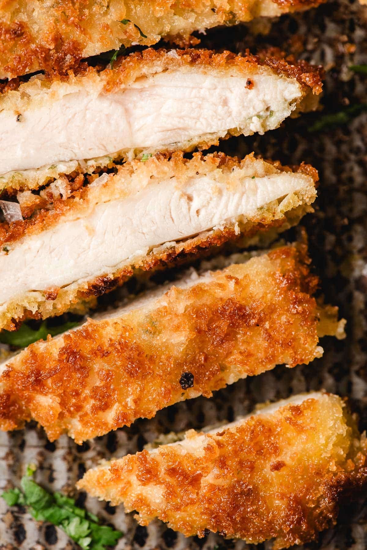 fried crispy chicken cutlets sliced to show the tender middle and crispy outside