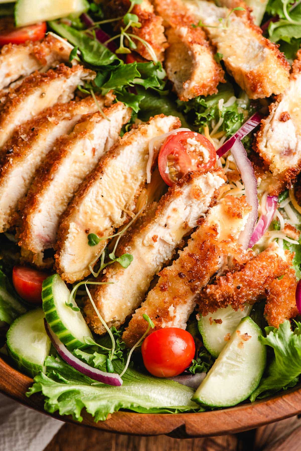 assembling the crispy chicken salad with chicken on top