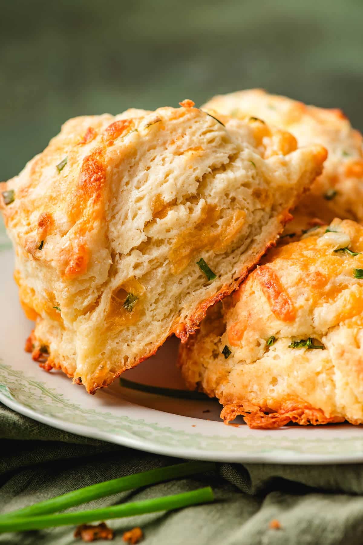 Side view of cheddar chive scones served on a plate.