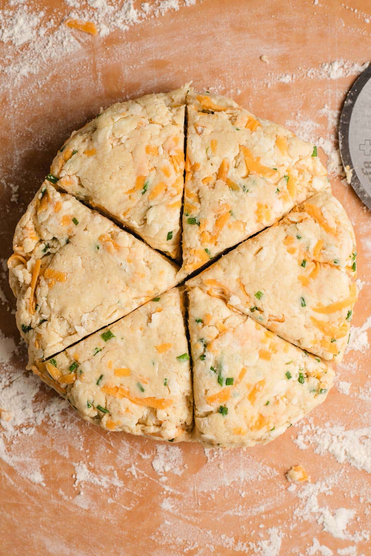 Scone dough shaped into a circle and sliced into six triangles.