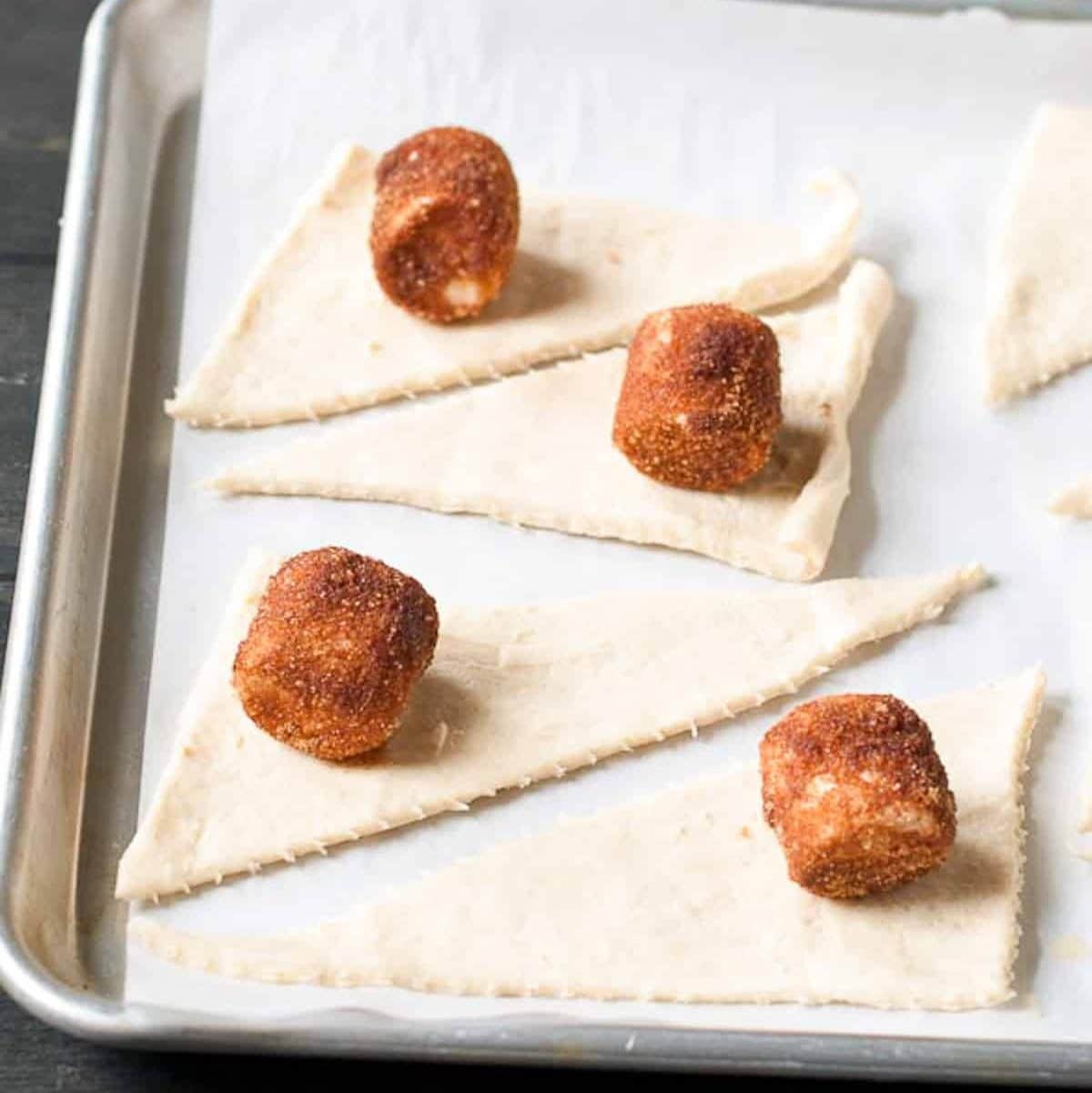 Cinnamon sugar marshmallows on top of crescent roll triangles.