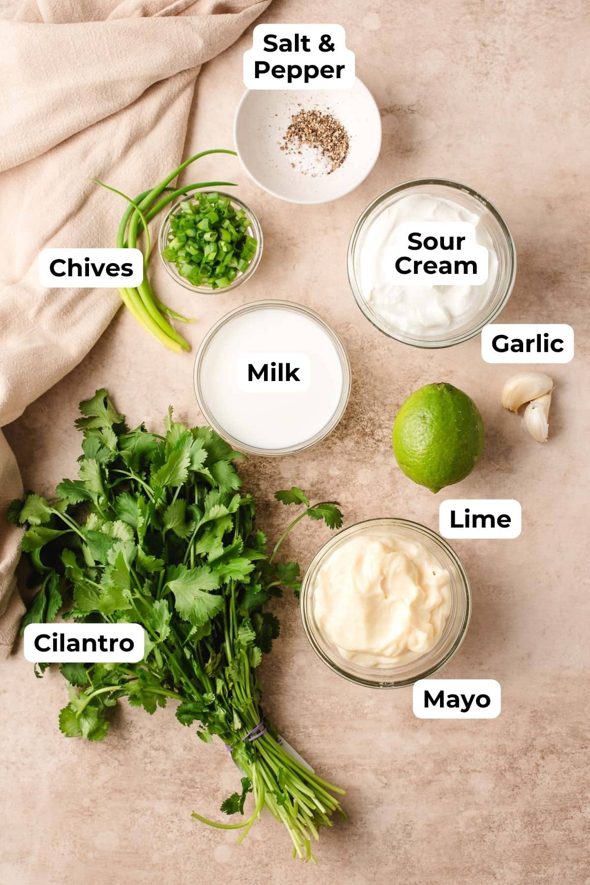 Sour cream, milk, cilantro, lime, mayonnaise, chives, and garlic in prep bowls.